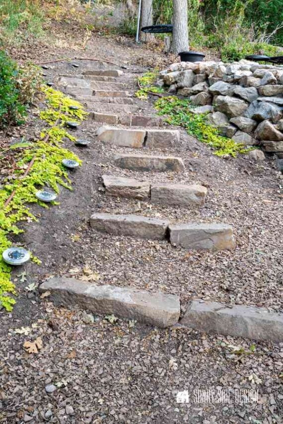 Simple stone steps in the backyard leading to a sloping garden path