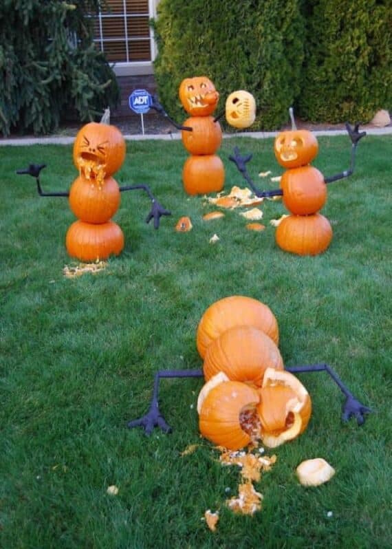 Pumpkins stacked as figures in a playful courtyard with broken and expressive lanterns.