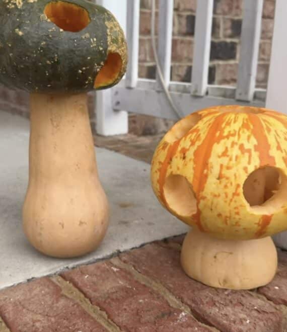 Pumpkins and gourds carved and stacked to resemble whimsical mushrooms.