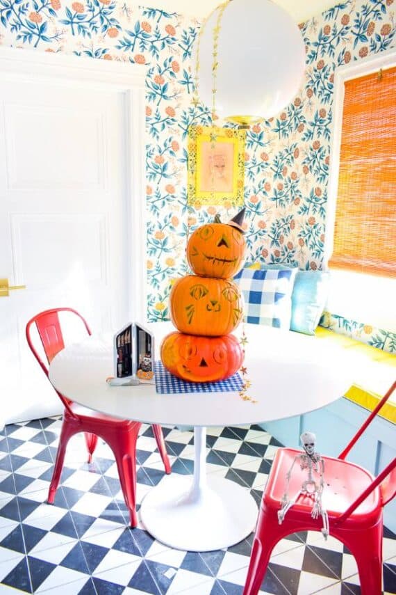Stack of carved pumpkins as a Halloween centerpiece in a colorful kitchen.