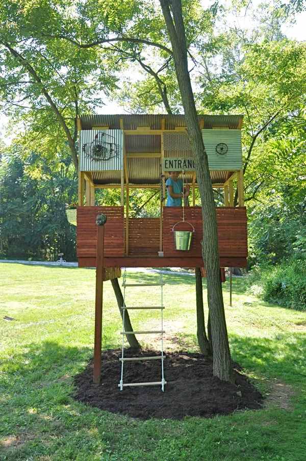 DIY Backyard Treehouse with Corrugated Metal Roof and Stair Entry.